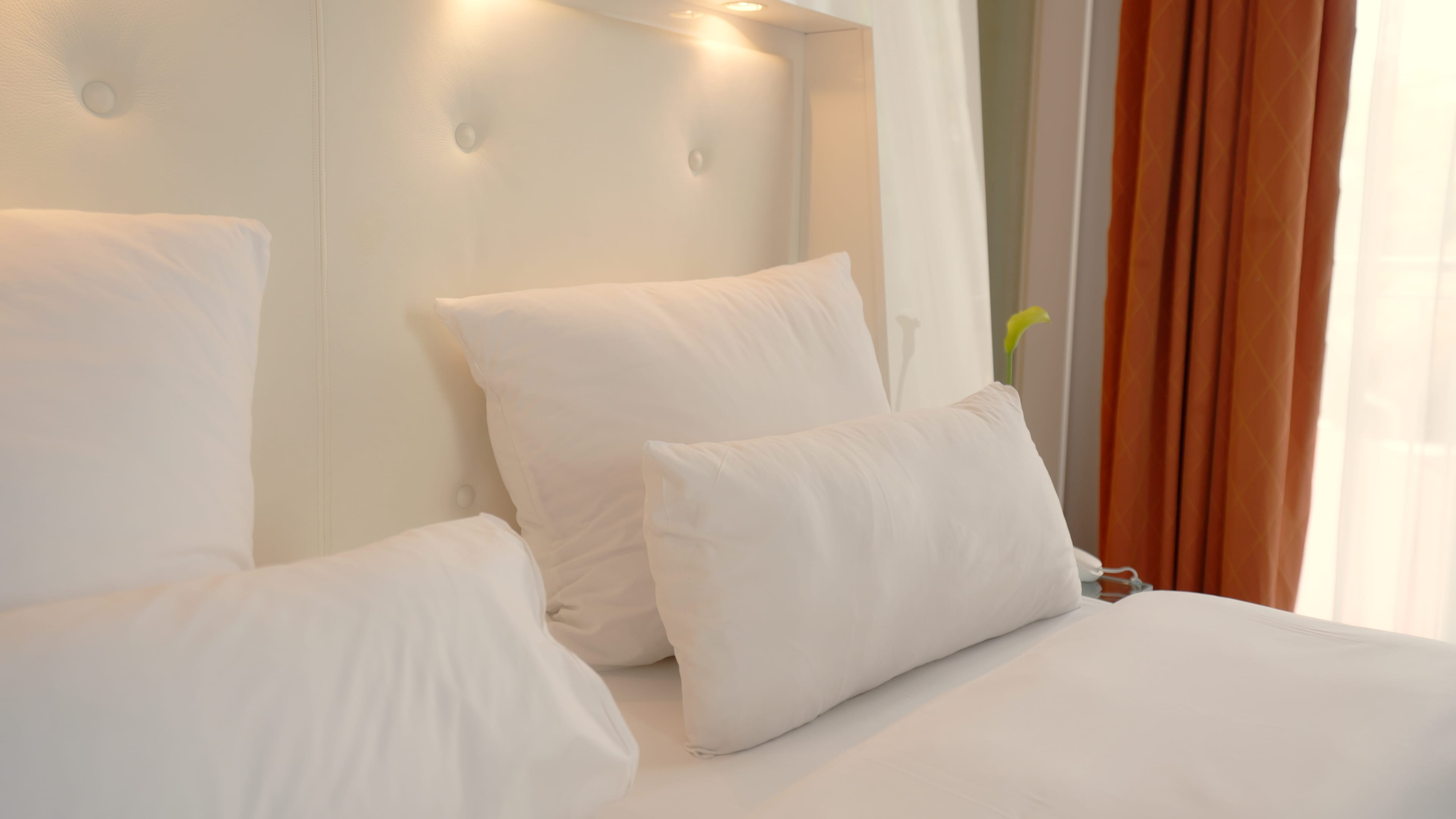 Frisch bezogenes Hotelbett mit weißen Kissen und Bettwäsche