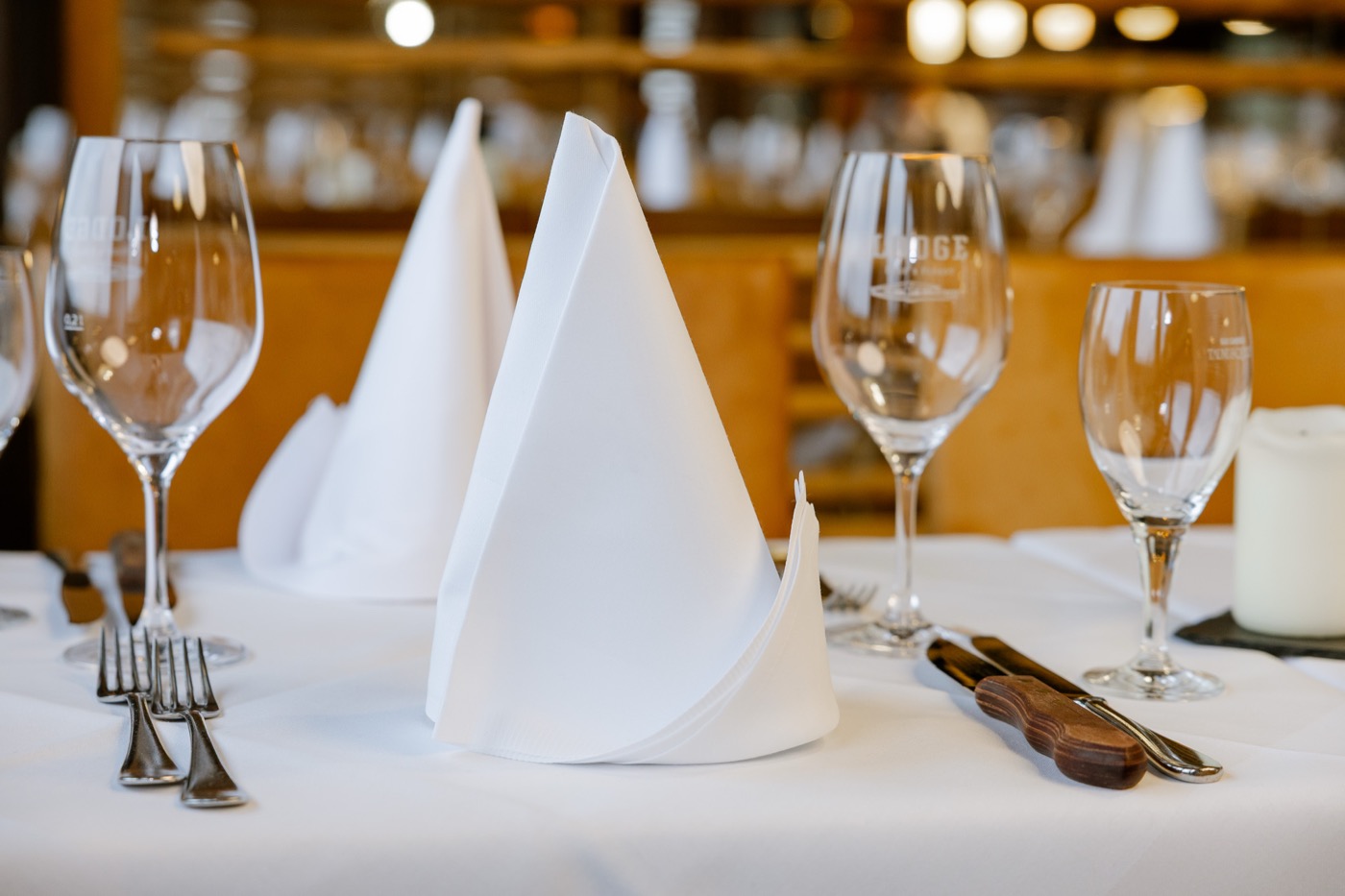 Eingedeckter Tisch mit weißer Tischwäsche und Servietten