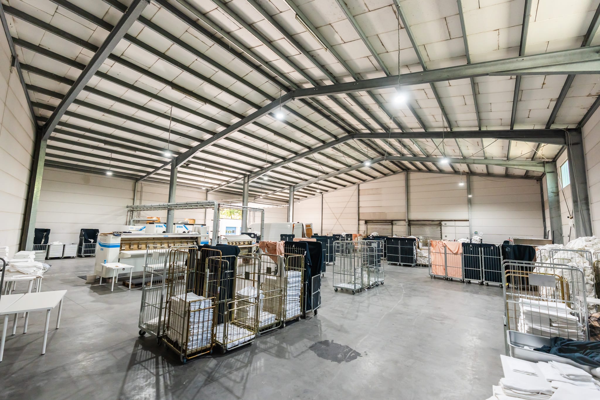 Unsere eigene Wäscherei in Karben — Mangelstraße und Wäschewagen in der Halle